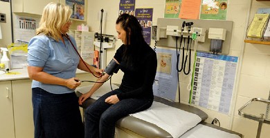 A health care provider measuring a person's blood pressure 