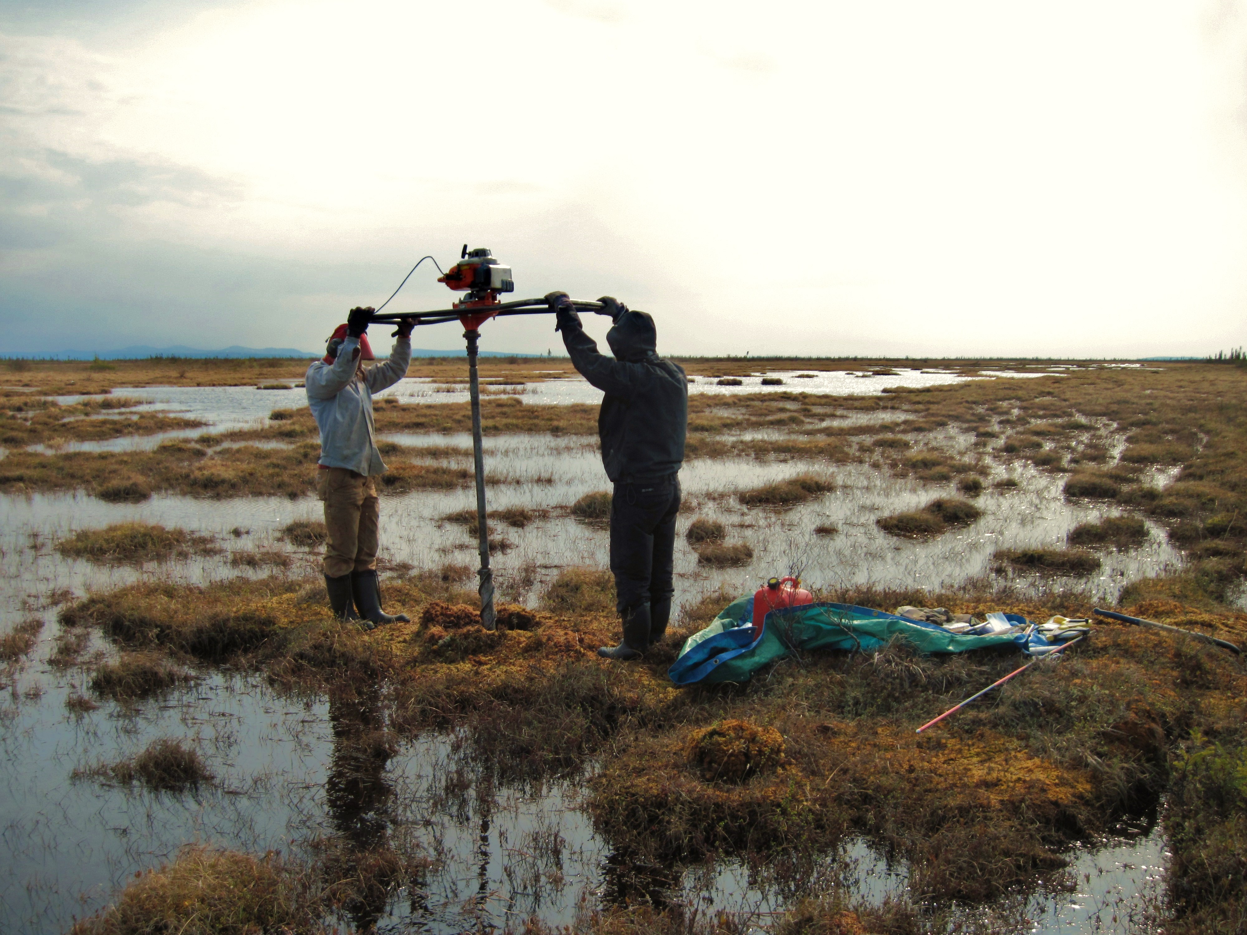 Two people taking permafrost samples for research purposes